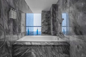 Relax in a spacious bathroom with a bathtub and city view.