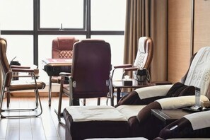 A hotel room with a large window, a desk, and two chairs. - Jing Cheng Hotel (Jiashan)