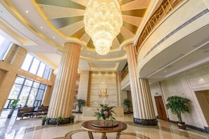 A spacious lobby with high ceilings, large columns, and a central chandelier. - Jing Cheng Hotel (Jiashan)