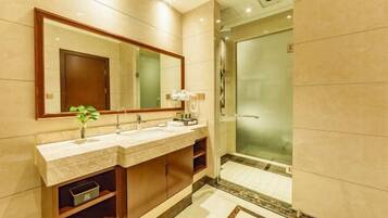A modern bathroom with a double sink vanity, a large mirror, and a glass-enclosed shower.