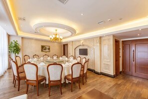 A formal dining room with a round table, chairs, and a chandelier. - Jing Cheng Hotel (Jiashan)