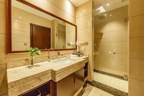 A bathroom with two sinks, a large mirror, a shower, and a potted plant. - Jing Cheng Hotel (Jiashan)