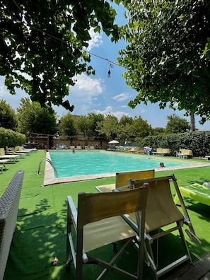 A swimming pool with lounge chairs and artificial grass. - Hotel La Torretta Bramante (Rimini)