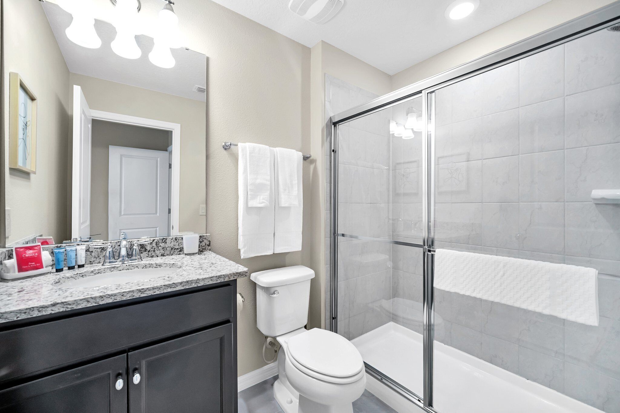 A modern bathroom with a shower, toilet, and vanity.