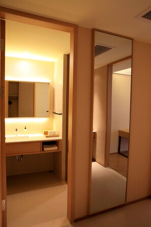 Un baño con espejo, lavamanos y barra para toallas.