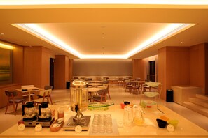 A spacious hotel lobby with multiple seating areas, a coffee station, and a reception desk. - Ji Hotel (Zhenjiang)