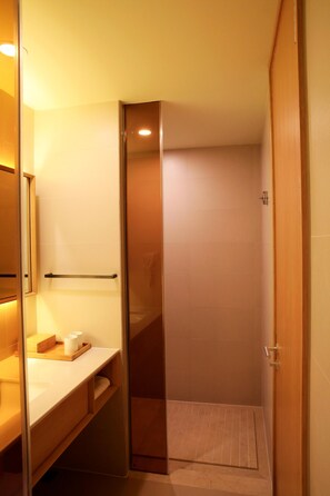 Un baño pequeño con tocador de madera, un perchero y una estantería.