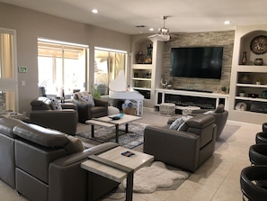 A modern living room with a fireplace, comfortable seating, and a large TV.