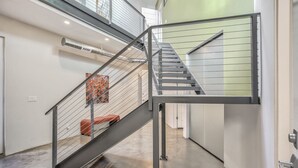 A modern staircase with metal railings and a red bench. - Modern Luxury I Mountain Views- central location- 4BR/3Ba (Colorado Springs)