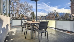 An outdoor patio with a table and chairs, overlooking a residential area with trees and houses. - Modern Luxury I Mountain Views- central location- 4BR/3Ba (Colorado Springs)