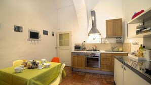 A compact kitchen with a dining area, featuring a stove, oven, and a small sink. - Stilmoderno 2 rooms apartment in Siena (Siena)