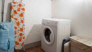 A laundry area with a washing machine, a drying rack, and a laundry basket. - Stilmoderno 2 rooms apartment in Siena (Siena)