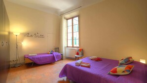 A bedroom with two beds, a window, a radiator, and a wall with a 'Sweet Dreams' sign. - Stilmoderno 2 rooms apartment in Siena (Siena)