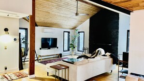 Ein modernes Wohnzimmer mit Sofa, Couchtisch und Fernseher.