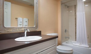 Un baño con lavamanos, espejo y ducha.