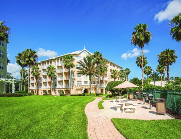 A hotel with a central courtyard, palm trees, and outdoor seating areas.