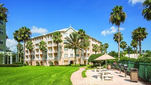 A hotel with a central courtyard, palm trees, and outdoor seating areas. - Club Wyndham Kingstown Reef - Studio Suite (Orlando)