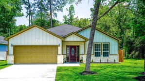 A single-story house with a garage, a front door, and a small porch. - Clean & Cozy new Home, 30 mins to George Bush INTL/ downtown 5 mins to woodlands (Conroe)