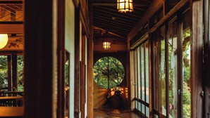 A corridor with wooden flooring, large windows, and traditional lanterns. - Takei Ryokan (Nagano)