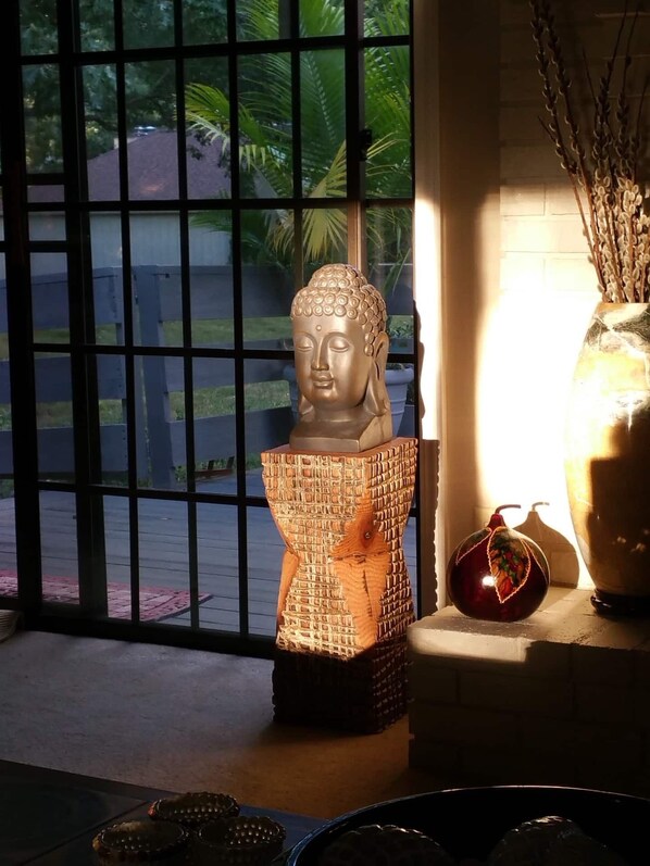 Eine Buddha-Statue in einem Raum mit Fensterblick auf eine Straße.