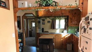 Une cuisine avec des meubles de rangement en bois, un plan de travail et un réfrigérateur.