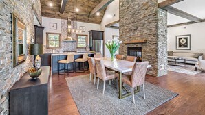 A spacious kitchen with a stone accent wall, a dining area with a large table and chairs, and a fireplace. - The Preserve Sporting Club & Resort (Richmond)