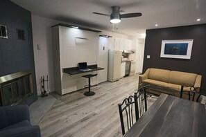 Una cocina moderna con comedor, sofá y ventilador de techo.