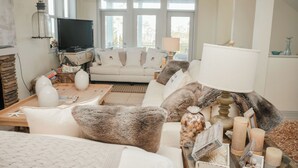 Ein Wohnzimmer mit einer Couch, einem Couchtisch und einem Fernseher.