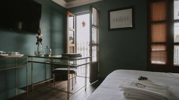 Una habitación con cama, escritorio, silla y ventana con persianas.