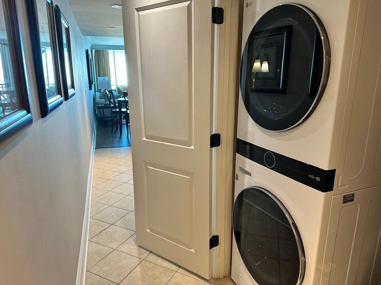 Lavandería con dos lavadoras, una puerta y vista a un comedor.
