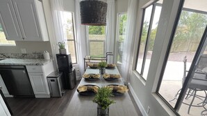 Ett modernt kök med ett matbord för fyra personer, där svarta tallrikar och gula servetter knutna med rosetter är framdukade.