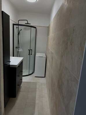 Regadera, secadora de cabello, toallas, papel de baño 