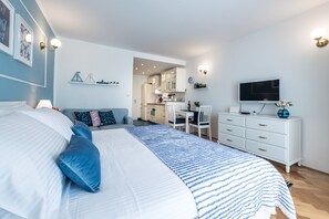 Ett sovrum med en stor säng, ett skrivbord och en tv.