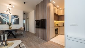 A modern kitchen with a built-in oven and a dining area with a table and chairs. - Two Bedroom Apartment with Terrace (Zadar)