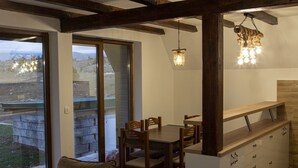 Un comedor acogedor con una mesa y sillas de madera, un sofá y una encimera de cocina empotrada con cajones.