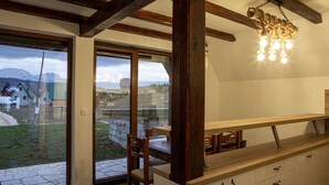 Una cocina moderna con vigas de madera, un ventanal y vista a un paisaje nevado.