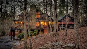Une cabane rustique avec une façade en bois, plusieurs niveaux et une véranda.