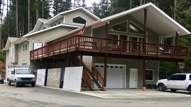 A two-story house with a wooden deck and a garage.