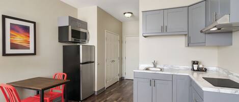 Cocina compacta con zona de comedor, que incluye refrigerador, microondas y pileta.