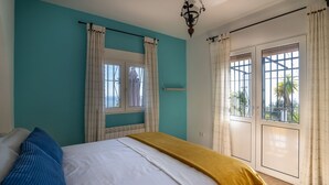 A bedroom with a bed, a window, and a view of the outdoors. - House of the Rising Sun - Luxury villa with private pool and stunning sea views (Sayalonga)