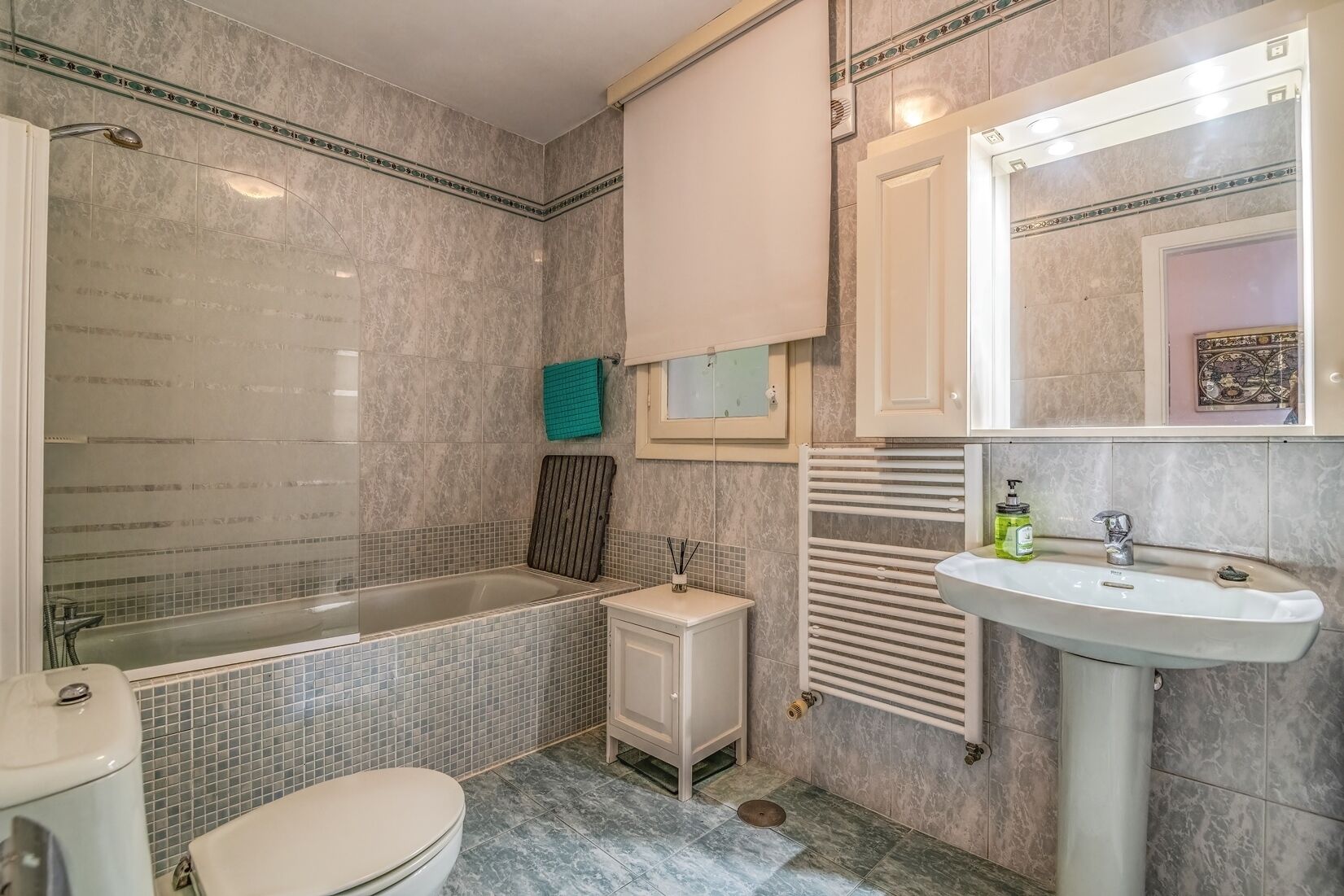 A bathroom with a bathtub, toilet, sink, and a towel rack.