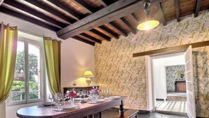 Un coin repas avec une table dressée pour quatre personnes, une lampe et une vue sur l’extérieur.