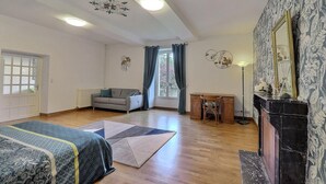 Une pièce spacieuse comprenant un lit, un canapé, un bureau et une cheminée.