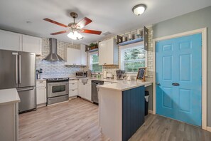 Enjoy cooking in this well-equipped kitchen with a central island, oven, and stainless steel refrigerator.