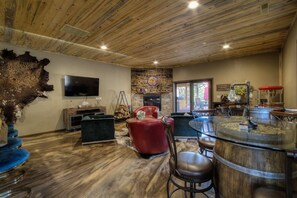 A rustic interior with a stone fireplace, leather furniture, and a wooden ceiling. - Stunning home on 7 acres with 5400sf of indoor/outdoor living space (Hermosa)