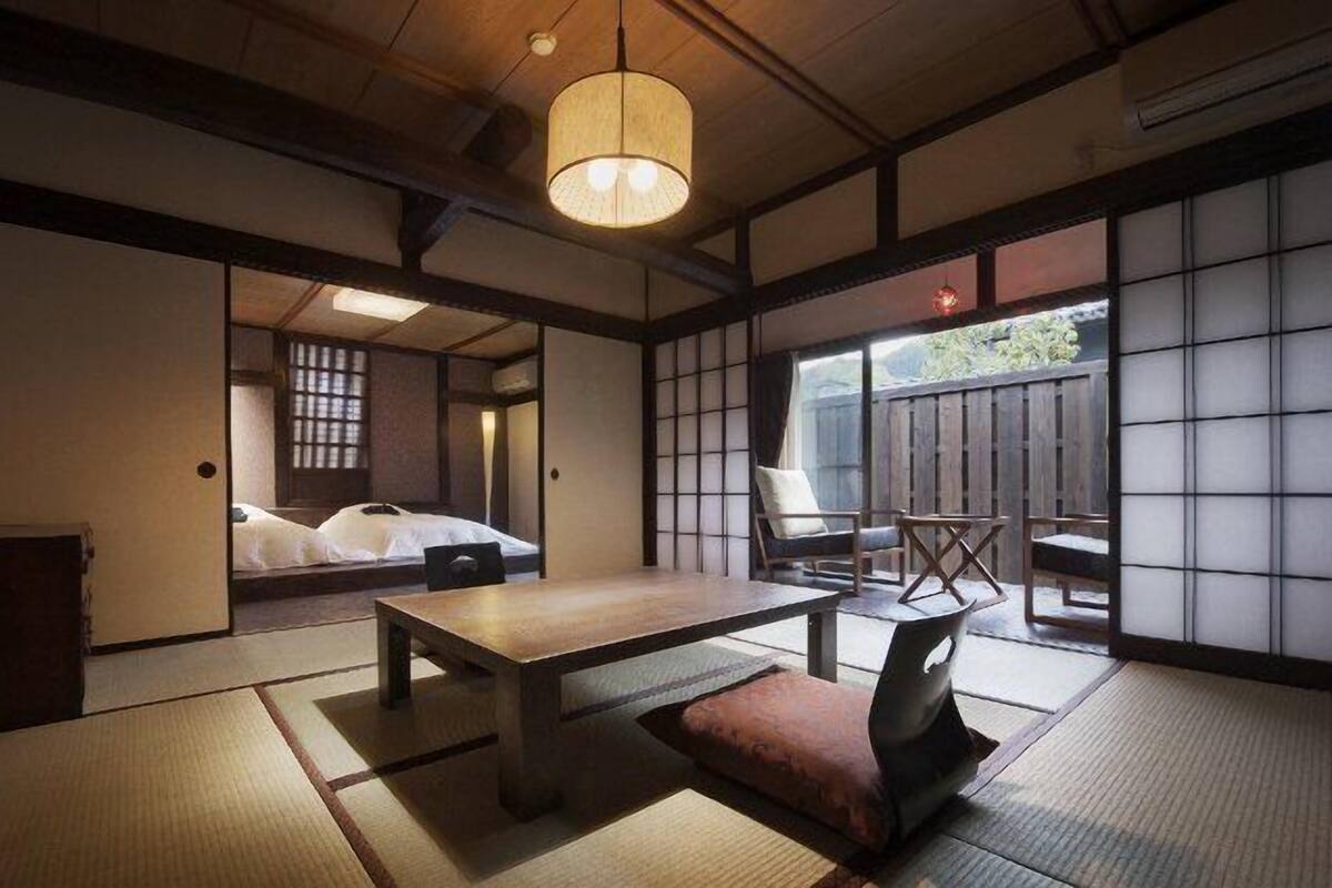 A traditional Japanese room with tatami flooring, a low wooden table, and sliding doors.