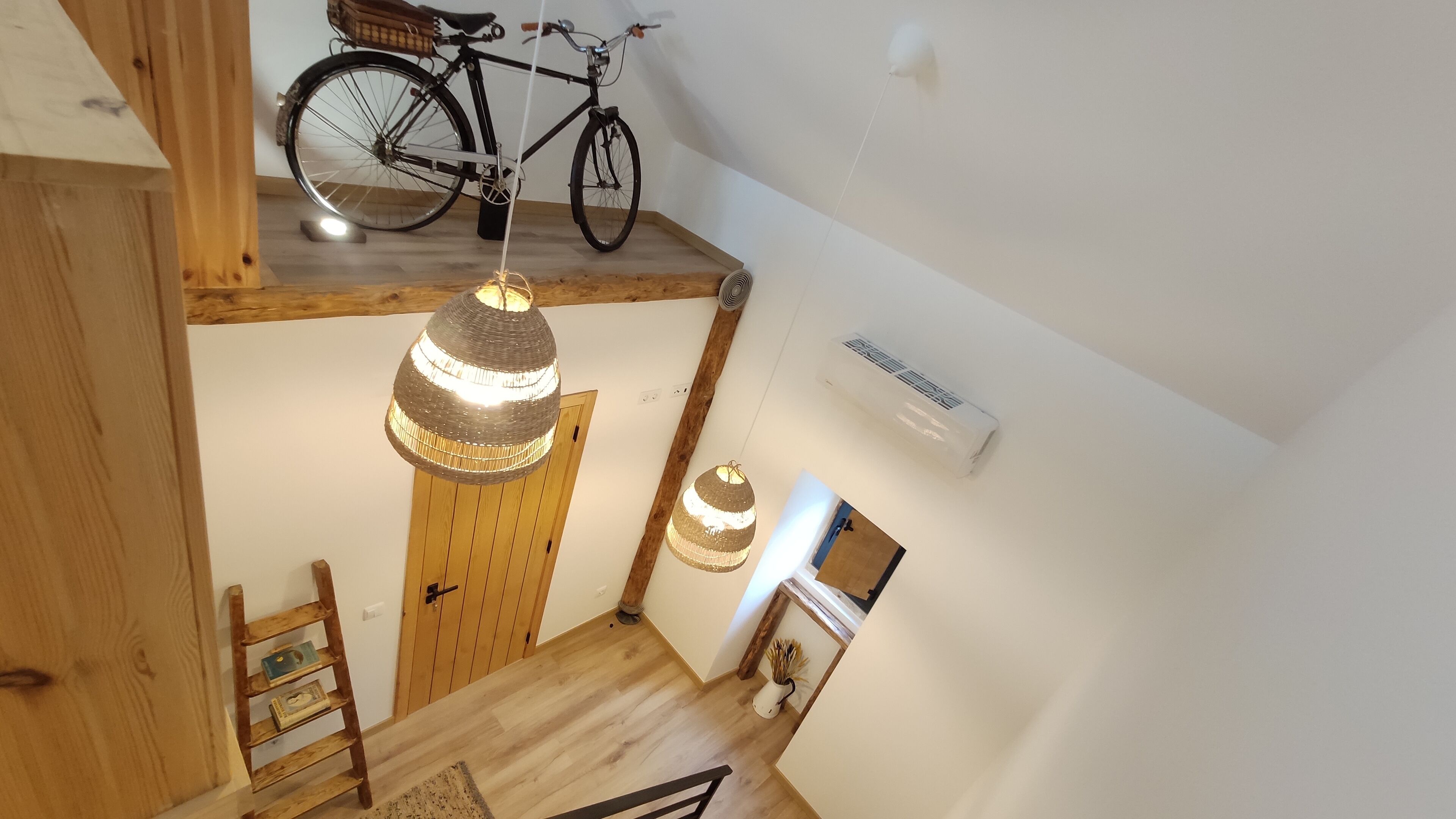 A wooden staircase with a bicycle on the landing.