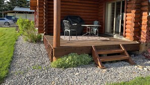 A log cabin with a deck, outdoor seating, and a grill. - Elk Run-Entire basement-1000 sq ft.-Cleaning fee included.  Sleeps 4-6. (Driggs)