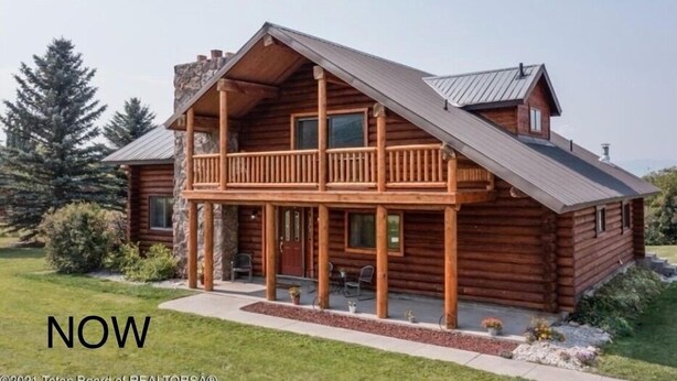 A log cabin with a balcony, a stone chimney, and a well-maintained lawn. - Elk Run-Entire basement-1000 sq ft.-Cleaning fee included.  Sleeps 4-6. (Driggs)