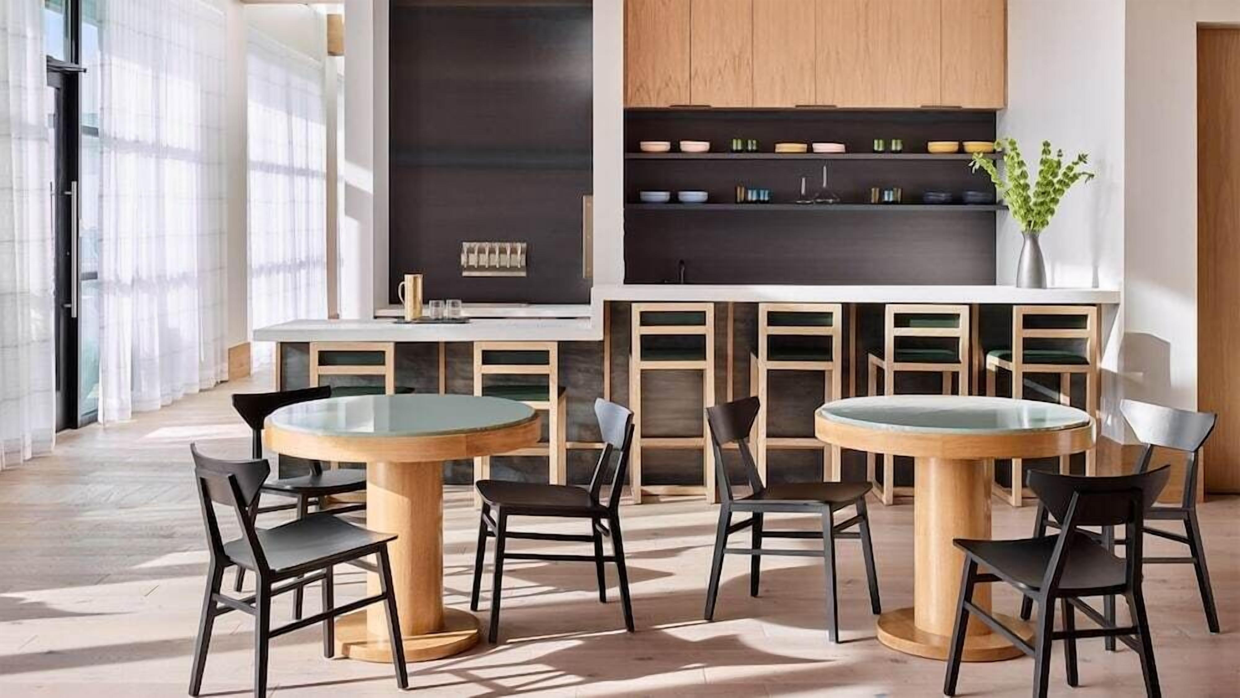 Una cocina moderna con armarios de madera, una isla central con asientos y vistas a la ciudad.